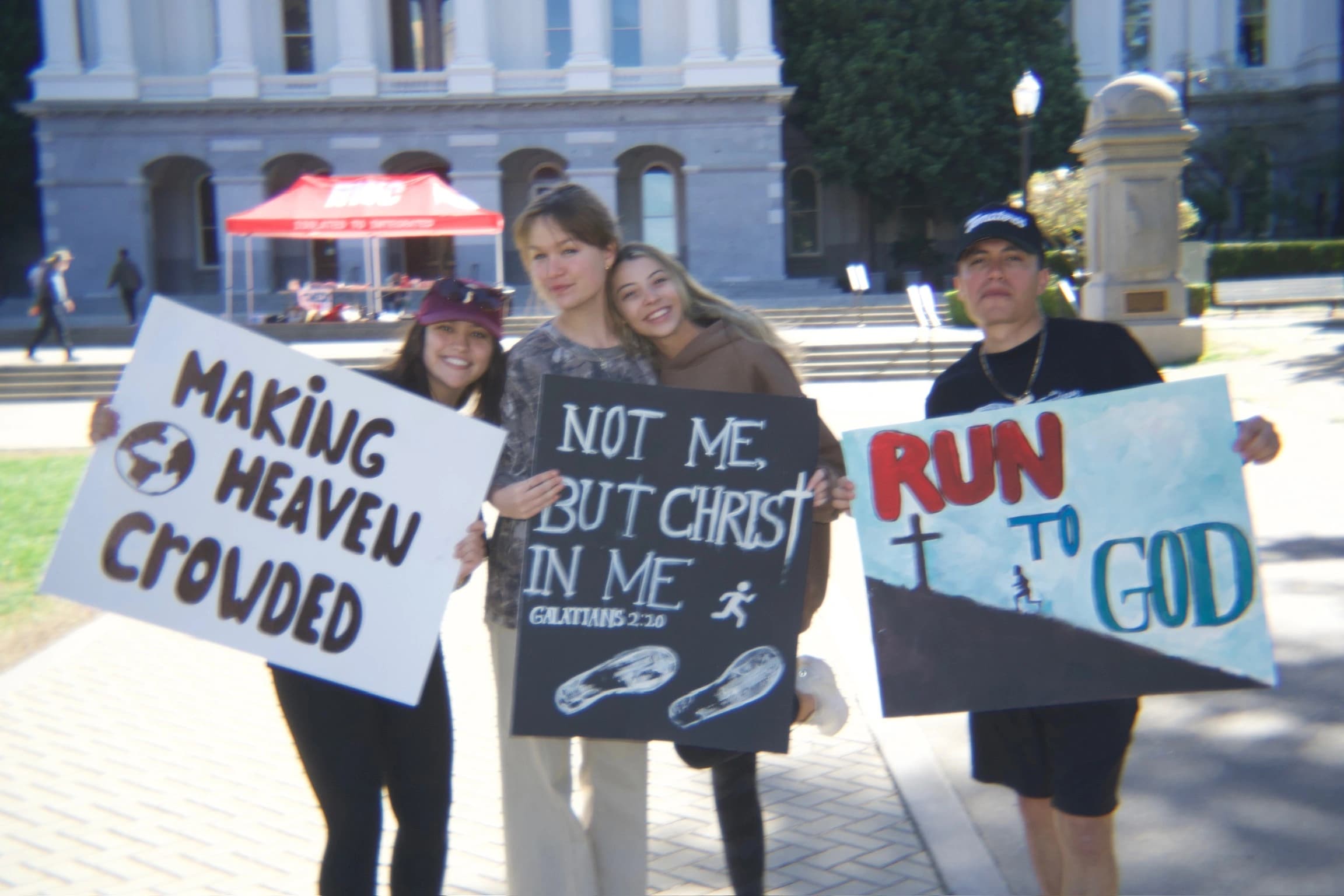Three people with posters